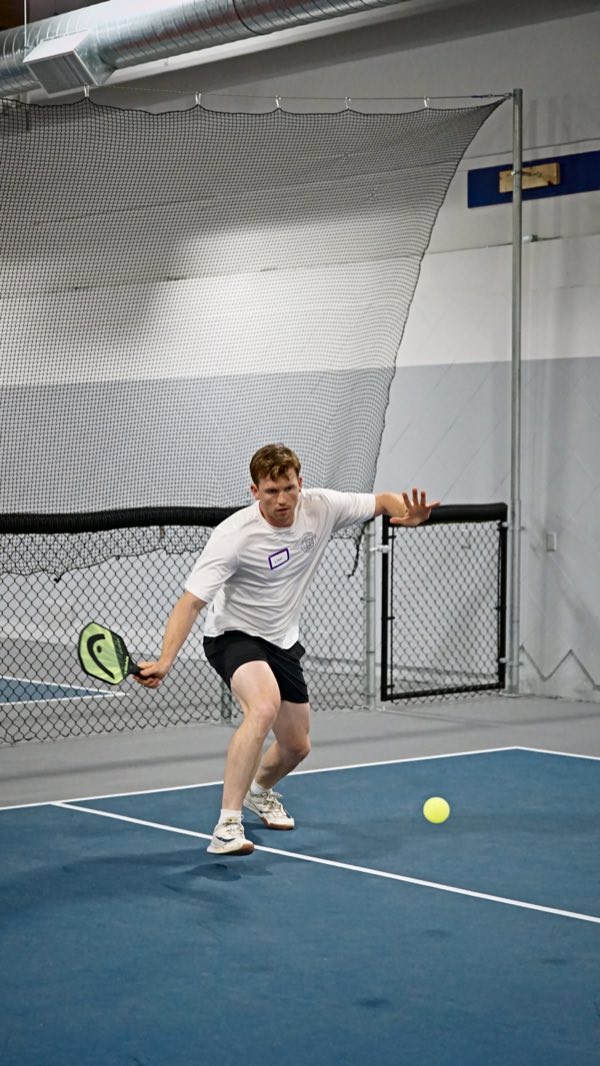 Eyes locked on the ball, a player stretches low to dig it out.