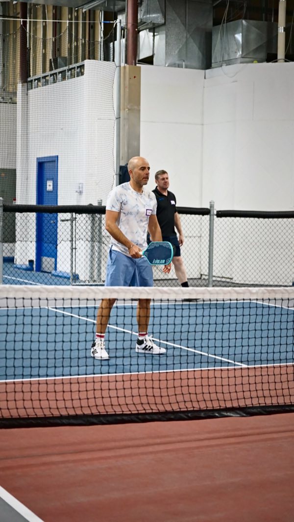 Across the net, a doubles pair waits on the serve.