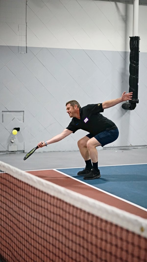 Full stretch at the net to keep the rally alive.