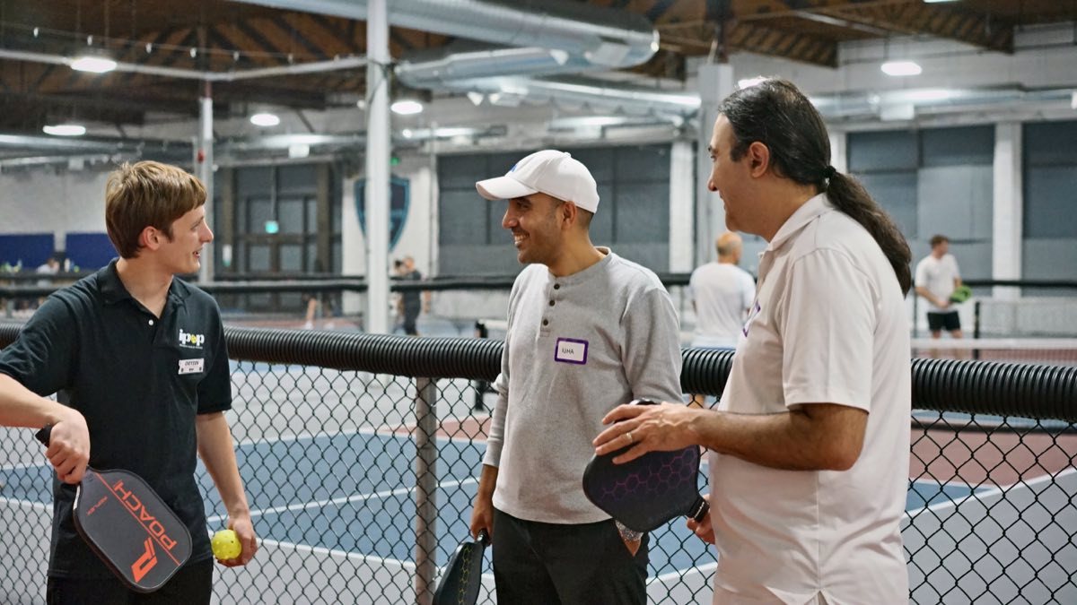 Three players sharing a laugh courtside between games.