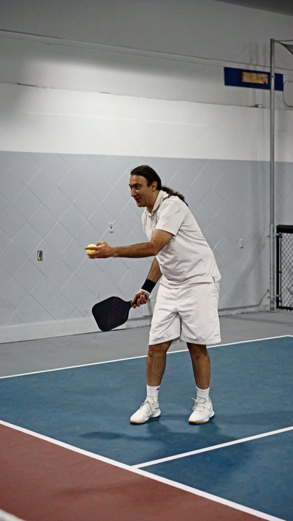 Lining up the serve with a grin that says there's a plan.