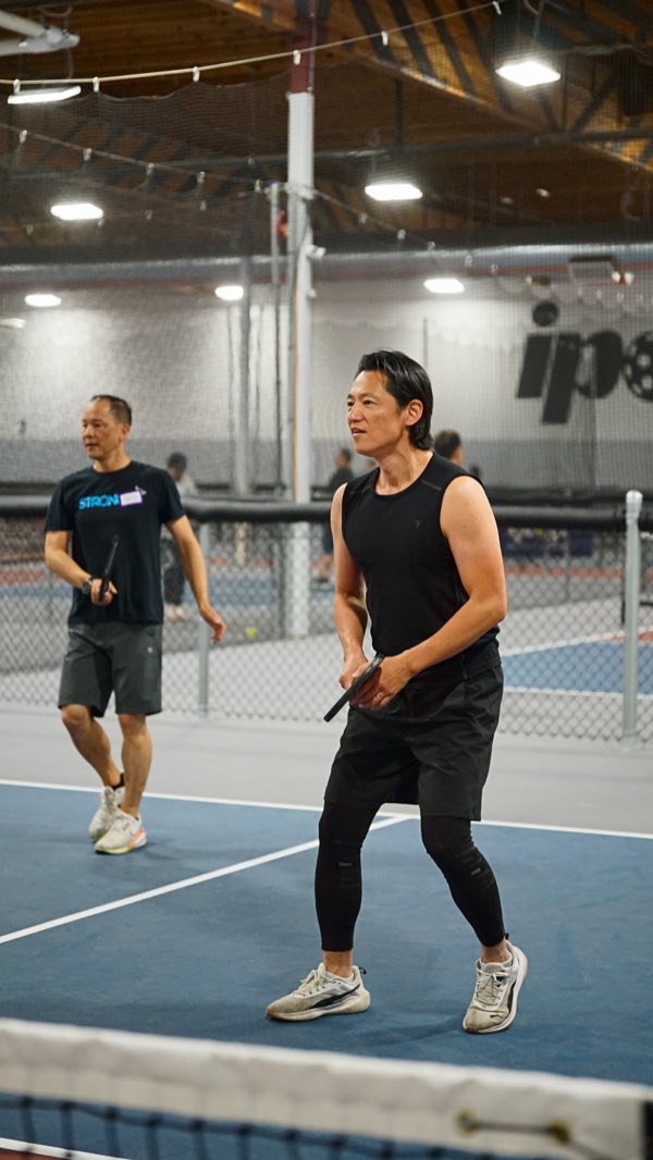 Partners on the same side of the net, both tracking the ball back over.